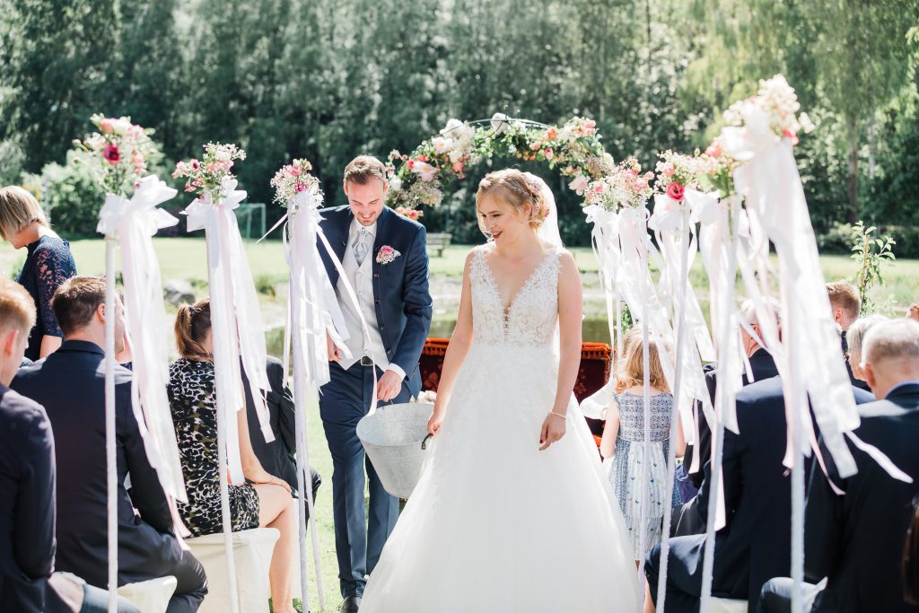 Braut und Bräutigam sammeln von Gästen mitgebrachte Erde