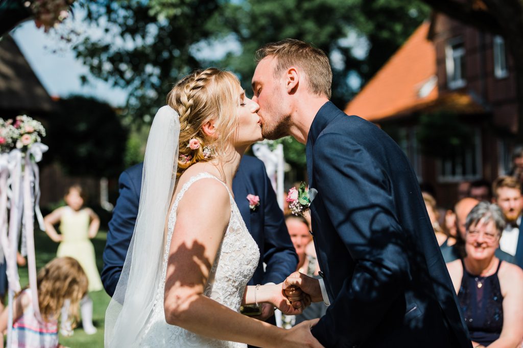 Braut und Bräutigam küssen sich nachher Trauung