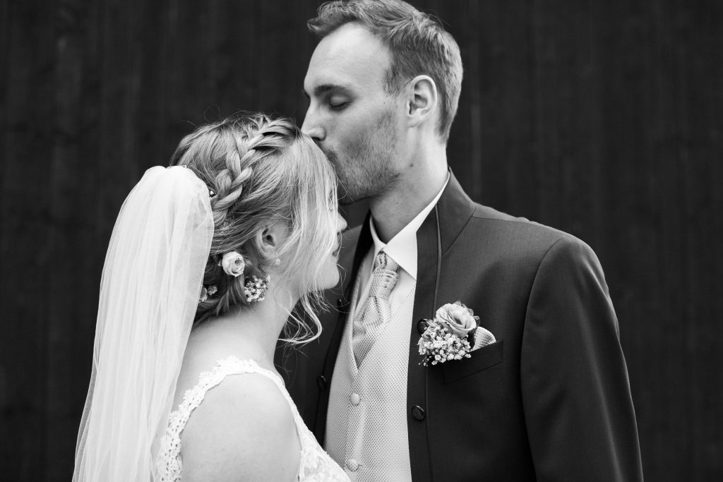 Bräutigam gibt Braut Kuss auf die Stirn