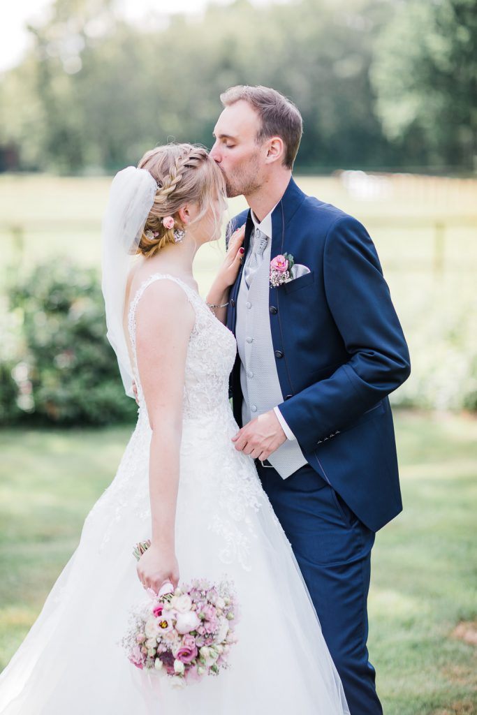 Bräutigam küsst Braut auf die Stirn