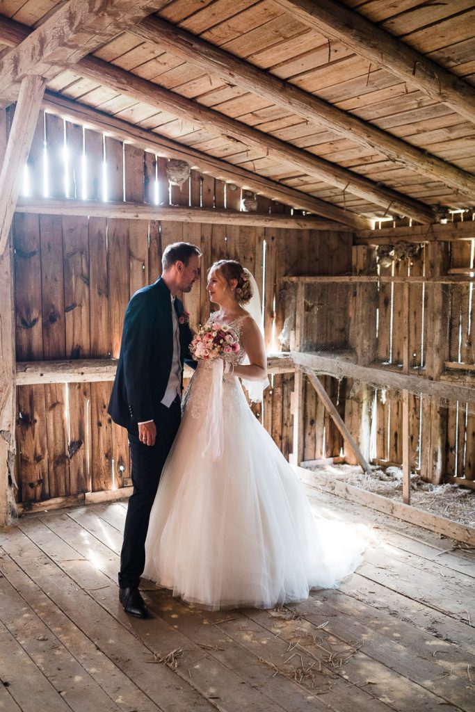 Braut und Bräutigam im Gegenlicht auf Dachboden einer Scheune