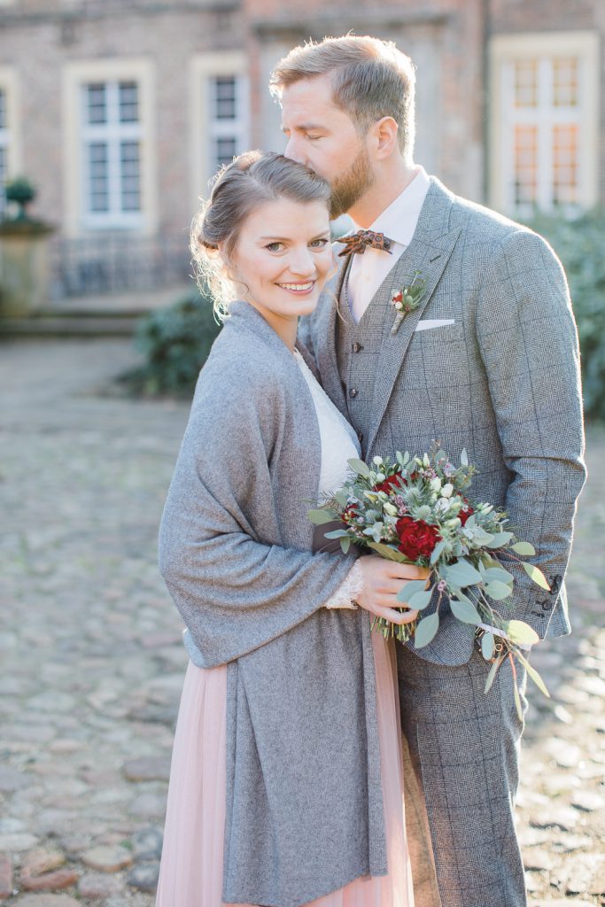 Bräutigam gibt Braut einen Kuss auf die Stirn