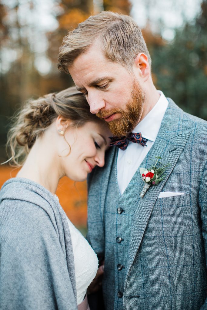 Braut lehnt an der Schulter ihres Mannes