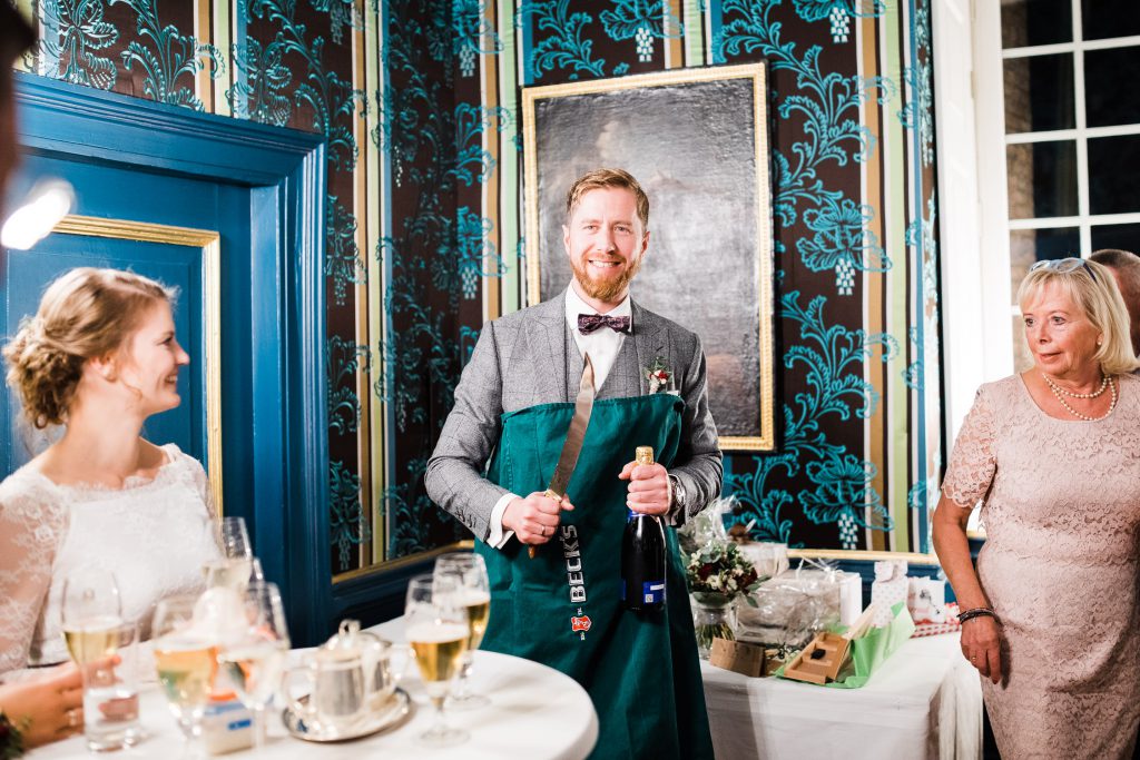 Bräutigam mit Säbel und Champagnerflasche